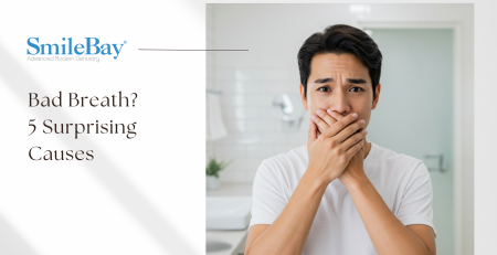 Concerned man covering his mouth due to bad breath in a bathroom setting